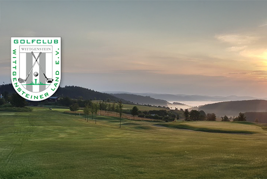 Golfplatz im Wittgensteiner Land bei Sonnenaufgang mit hügeliger Landschaft und Nebel in der Ferne.