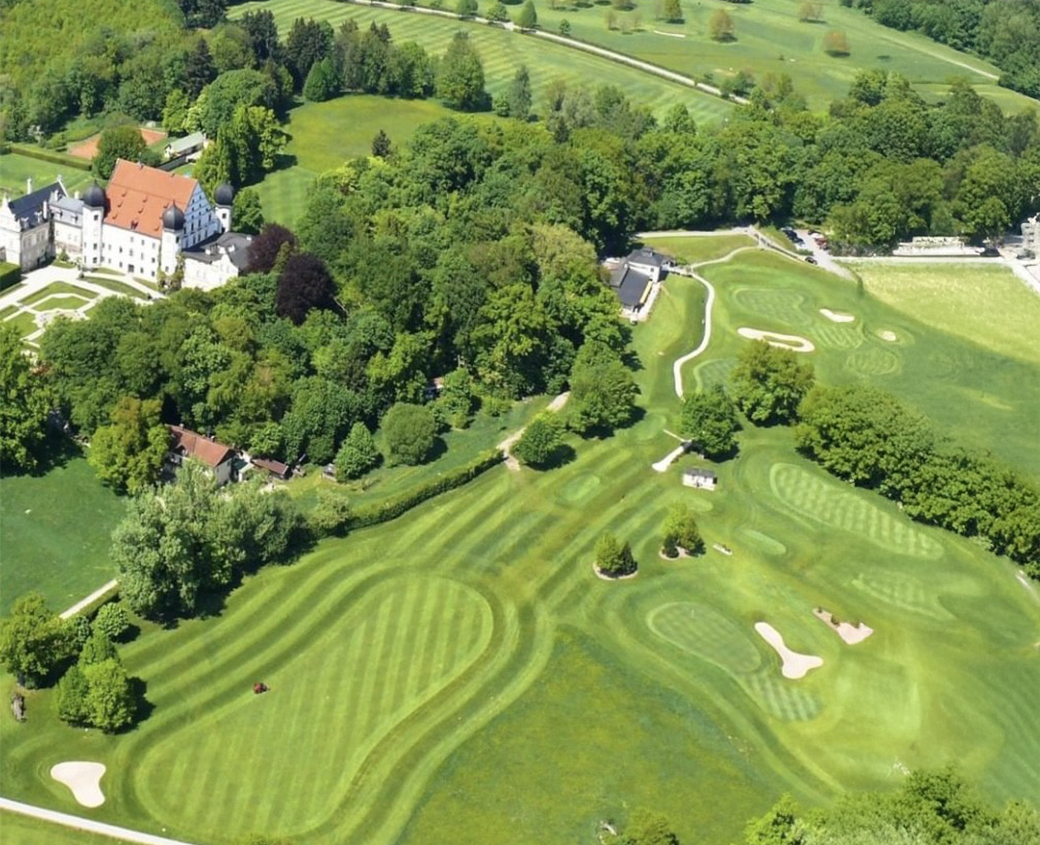 Bild einer Golfanlage mit sanften Hügeln und hellem Gras.